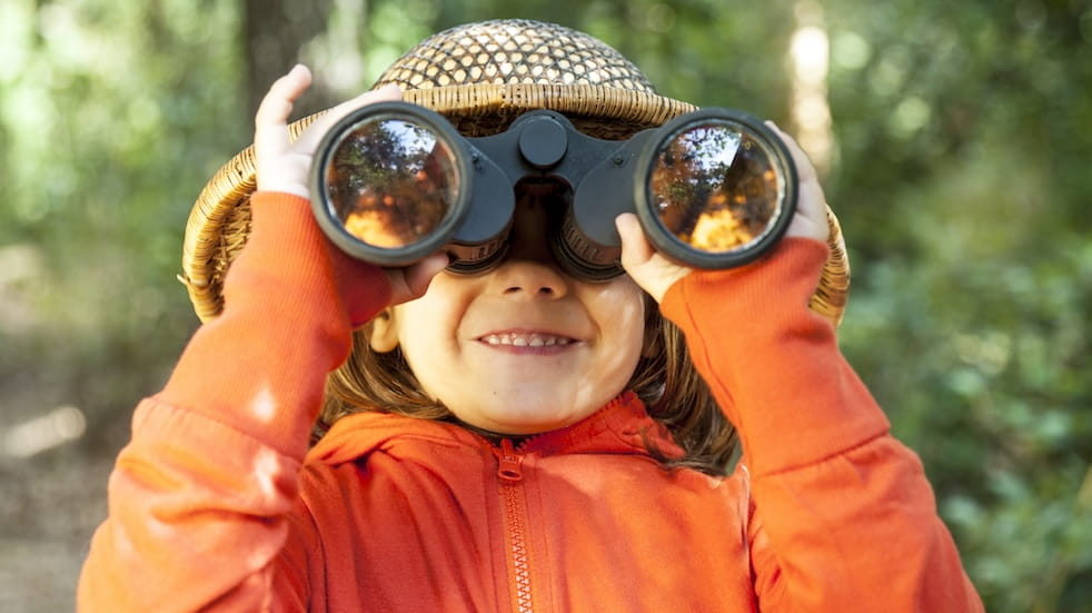 Young girl looking through binoculars